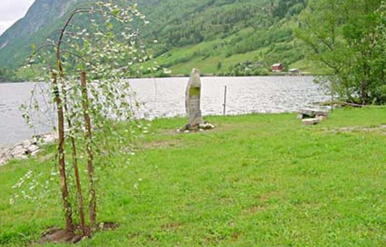 The millennium stone at Holsen with the three units: millennium stone, stone seats, and millennium tree. Holsen farmers' wives union was responsible for the tree, which was planted on the Norwegian Day of Liberation, 8 May, 2001.