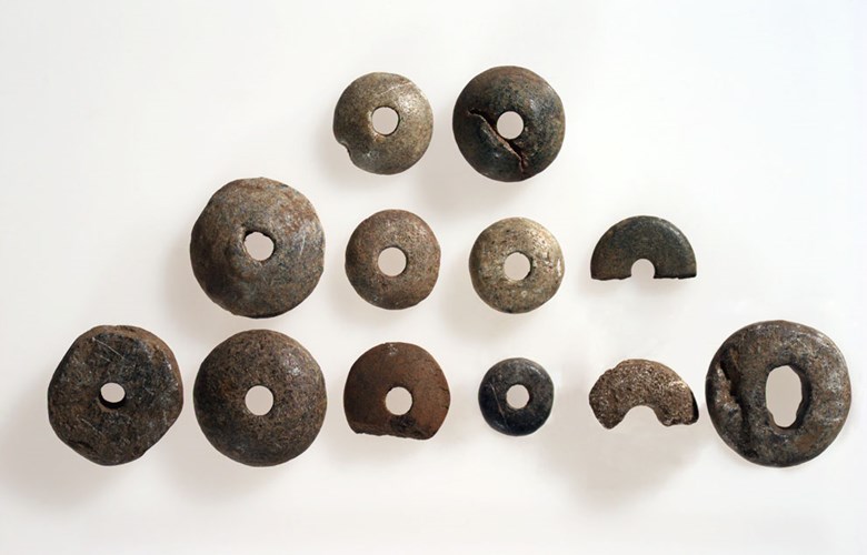 Whorls from Ytre Moa. The whorls are made of different types of materials, and they vary in weight and size. The size of the holes also varies. Whorls of this type can be dated to the Iron Age / the Middle Ages. (Photo: The County Archives of Sogn og Fjordane).