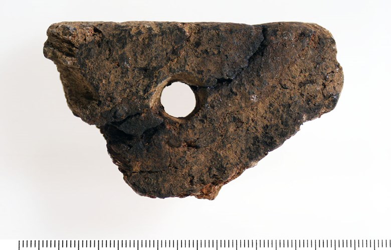 Fragment of soapstone vessel found at Ytre Moa. A handle has probably been attached through the hole. Most likely the vessel has had the same form as the vessel in the drawing (picture 2). Soapstone vessels of this type can generally be dated to the Iron Age / the Middle Ages, but they have actually been in common use until fairly recent times. (Photo: The County Archives of Sogn og Fjordane)