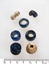 Various beads from Ytre Moa, showing a blue and white so-called double bead and simple glass beads. This type of bead can generally be dated to the younger Iron Age (Photo: The County Archives of Sogn og Fjordane).