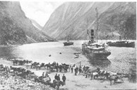 Steamers in the Gudvangen harbour, with horses and carts lined up to transport passengers up the Nærøydalen valley to Stalheim. The picture is from 1912. 