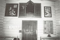 In 1977, the new organ was placed in the room above the porch. To the left is a painting from 1675, with the motif 'Virgin Mary and the Holy Infant'. The painting has an inscription in Latin 'Maria Mater Dei' (Mary God's mother) - Anno 1675, and I.P.S.I.D. (Jørgen Post and Sofie Jonsdotter). To the right is a painting from 1642 with the motif 'David being anointed king', (1. Samuel; 16). It is based on Virgil Solis' woodcut from 1562. The inscription is: P.J.1642 (Peder Jørgenson, bailiff in Nordfjord 1624-33).