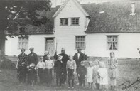 A big crowd of people in front of the bailiff farm - probably in 1927. From left to right: Petra, Karl, Helge senior and Kristoffer Bruland - the latter holding gaffs. The children are: Einar, Sverre, Konrad, Ola, Helje, Ludvik, Gullborg, Gunda, Jenny and Gudrun Bruland.