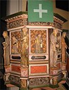 The pulpit from 1672, made by an unknown artist, is adapted to the altarpiece and earlier probably had a panelled canopy. It was installed in this church in 1942. On the front of the pulpit there are carved sculptures of Christ in the middle, and apostles and evangelists, each with a book. The figures are Matthew, Jacob the younger, Mark, Peter, Christ the Saviour, Paul, Luke, Simon, and John.