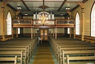 From the interior of the church, from the nave towards the gallery and the porch. The gallery was extended in 1902. At the same time, new loose pews were installed. The organ dates from 1913 and has seven registers.