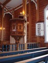 The pew seats are painted blue, and otherwise painted in oak colour with individual numbers for the various farms and families. The walls are of wooden colour. The church room has columns supporting the gallery, also functioning as roof supports to the sides