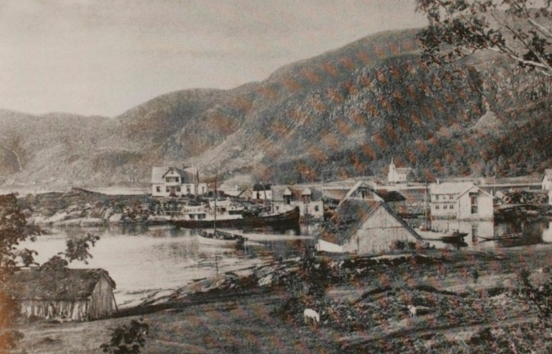 View of Selje in 1907. The boat at the quay is probably Stavenes. The boat in the centre of the picture is the first boat with engine that came to Silda. Albert Silde owned the boat. Silda did not have a good harbour at that time, so the boats were often anchored up in the bay of Seljevågen. The motorboat behind the warehouse of Josef Grytting may be one of the first motorboats in Selje. 
