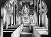 A total of 20 staves support the church room itself, in addition to two solid staves in the chancel. Of all the stave churches, this is the one with the least carvings and decorations. 

Dating: 1966-1970.<br />
Owner: In <i> Kaupanger <b>+ N</b>.</i><br />
Photographer: Unknown.
