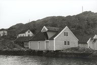 Steindalen with the sea warehouses and Sjøstaua, the small, white cottage, which is believed to have been moved from Utvær by way of Stokkevåg to Steindalen, where it was also moved and is now standing on its second site.