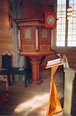 The pulpit from 1863 and the font have parts from 1703. We see the lectern in the foreground.