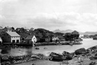 The oldest boathouses and sheds at Færøy were built for fishing with rowboats in home waters. As the fisheries grew, bigger sea warehouses were built. The house to the left is Nystø, with room for two dories downstairs, and accommodation for the seine repairmen upstairs. The dories on the beach belong to Br. V. Færøy.<br />
The long breakwater was built in stone by Wilhelm T. Færøy, who transported the stone from his own fields, by horse, sledge, and cart.<br />
In 1961-1963, a breakwater was built with public funds, and only then did Færøy have a secure and good harbour.