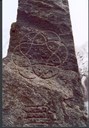 The sun wheel symbol is inscribed on the front (the east side) of the stone; the wreath symbol on the back.