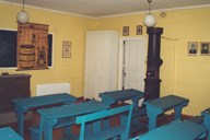 The classroom is now furnished as a typical school room from the early 20th century. Notice the fine old wall chart and the elegant wood stove. It was the teacher's responsibility to warm up the classroom before the pupils came. Therefore, he had to get up early to light a fire.