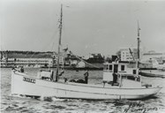 The second shipment of arms to Sogn was on the Enstad fishing vessel "Trio". This was the biggest of the shipments. Nils Enstad, Petter Færøy, and young Reidar Engevik were onboard. On their way east, Nils dropped by the German signal station at Tungodden and was given a fresh stamp in his boat passport! There was no quay, so the fishing vessel waited in the sea with the engine at dead slow while Nils rowed ashore. Both the "Per" and the "Trio" had seines over the hatch to avoid suspicion. Both boats had in addition explosives in the hold, with the ignition control in the wheelhouse. Under no circumstances would the arms get into German hands.<br />
The picture shows the fishing vessel after she was extended and had a new wheelhouse. The family Enstad moved to Øygarden in 1961.