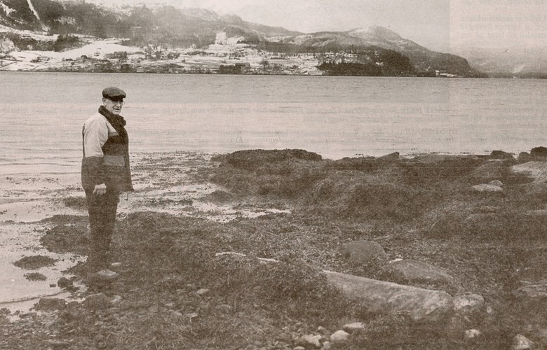 Harald Bakke beside the menhir on the beach of the farm of Bakke in Holmedal.
