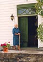 Karoline Kjørnes, born 1910, lived many years in the old house at Kjørnes. She can still remember the meeting at Kjørnes in 1917 to commemorate the centenary of Schreuder's birth. The picture shows her standing on the stairs up to the main entrance of the house.