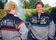The Flora sweater is designed and knitted by Ågot Pedersen. The colour scheme is grey, white, red, and blue. The front shows motifs of the Kinna church and the Stabben lighthouse, and the motifs of the back side are inspired by the Ausevik rock carvings.

