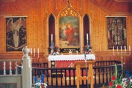 The chancel has a plain but warm form, and the light panelling provides a good backdrop for the altarpiece and the tapestries on the sides. The tapestries are made by Emma Breidvik, the one to the left shows an angel and the one to the right depicts a representation of the Crucifixion at Calvary. The altarpiece is painted by Anders Askevold and its motif is 'Jesus in the garden of Gethsemane'.