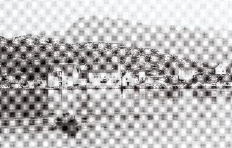 Rugsund in the 1880s. The warehouse, the store, and the residence in the centre of the picture. To the right of these buildings, a short distance from the sea, is the bakery. The bakery was in the cellar of this building, whereas the ground floor was used as a court room for some time. At present the bakery is used for accommodation.
