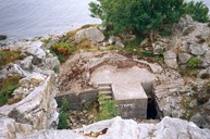 In this picture we can see the half-finished command bunker with a staircase down to the mountain halls below. On top of the concrete floor of what was meant to be the observation room, concrete walls and roof should be built. The same type of bunker can be seen completely finished at Lammetun.