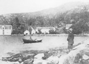 Bryggja as the place looked like before the fire in 1898. We do not know the names of the man in the rowboat or the boy on the shore.