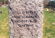 The stone has the shape of a prism, roughly hewn, and has inscriptions on two sides. At the back: ERECTED BY BYRKNES * NEIGHBOURS AND NEAREST * HAMLETS IN DEEP  * GRATITUDE