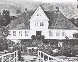 The old main building at Askelund. This house is without the two small dormers, which were built later, and with a round window in the dormer. The chimneys were altered shortly after this photo was taken. We notice that the veranda has the old shape with the stairs leading to the main entrance. Later the house was fitted with a round veranda and stairs on each side. This picture shows the house as it was in the bailiffs' time. 