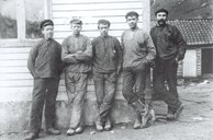 The picture shows five of the first shift workers at the aluminium plant in 1908. From left to right: Jakob Mjåseth, Konrad Yndestad, A. Skrede, Laurits Yndestad, and the Swedish blacksmith Johan Viktor Kilberg.
