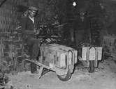 Brick workers taking burned stone out of the furnace. The wheelbarrows are fitted to the bricks, and there are 50 stones in each wheelbarrow.